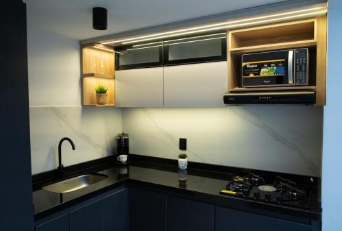 a kitchen with a sink and a microwave at La Haus Paipa beautiful and modern house in Paipa