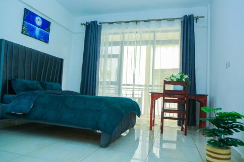 a bedroom with a bed and a table and a window at Stylish 3-bed Ensuite Apt in Westlands in Nairobi