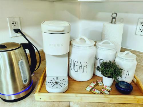 a coffee maker on a wooden tray with three cups at Langley Heights 2 Bedrooms Sweet Suite in Langley