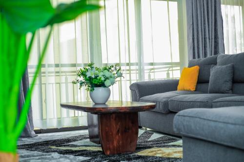 a living room with a vase of flowers on a table at Stylish 3-bed Ensuite Apt in Westlands in Nairobi