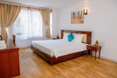 a bedroom with a large bed and a window at Lanxy Hotel Nha Trang in Nha Trang