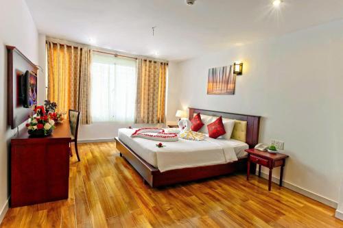 a hotel room with a bed and a window at Lanxy Hotel Nha Trang in Nha Trang