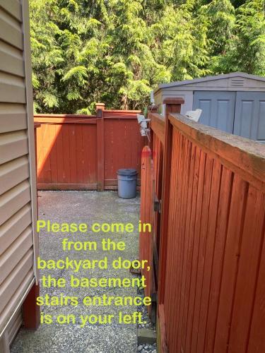 a sign on a fence that reads please come in from the backyard door the assessment at Langley Heights 2 Bedrooms Sweet Suite in Langley