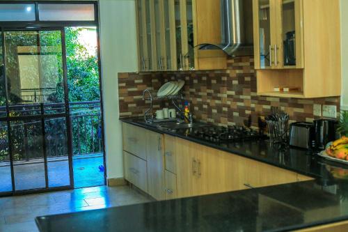 a kitchen with a sink and a stove top oven at Stylish 3-bed Ensuite Apt in Westlands in Nairobi