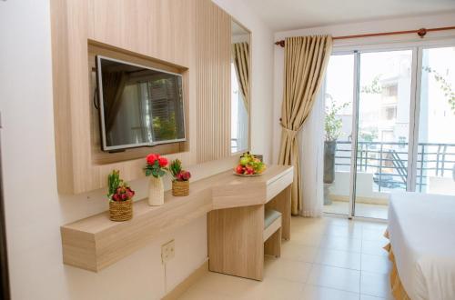 a room with a vanity with a mirror and a television at Lanxy Hotel Nha Trang in Nha Trang