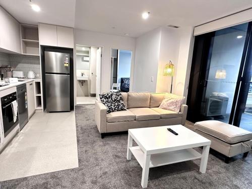 a living room with a couch and a table at Town Center 1 Bedroom Cozy Home in Belconnen