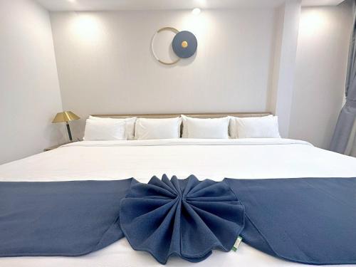 a large white bed with a blue flower on it at Thanh Premier Da Lat in Da Lat