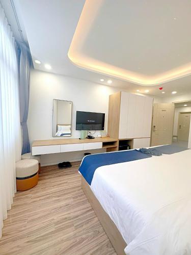 a bedroom with a large bed and a television at Thanh Premier Da Lat in Da Lat