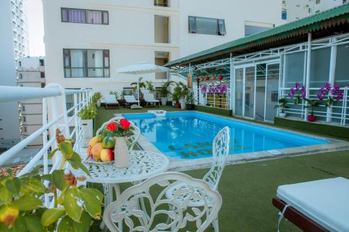 a balcony with a table and chairs and a pool at Lanxy Hotel Nha Trang in Nha Trang