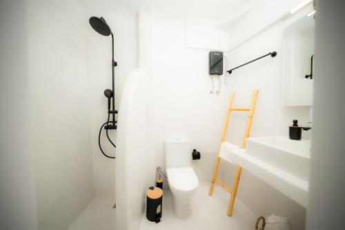 a white bathroom with a toilet and a sink at Kythrooms 1 in Kithnos