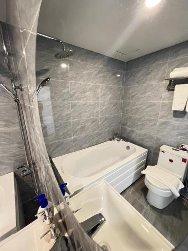 a bathroom with a tub and a toilet and a sink at Thanh Premier Da Lat in Da Lat