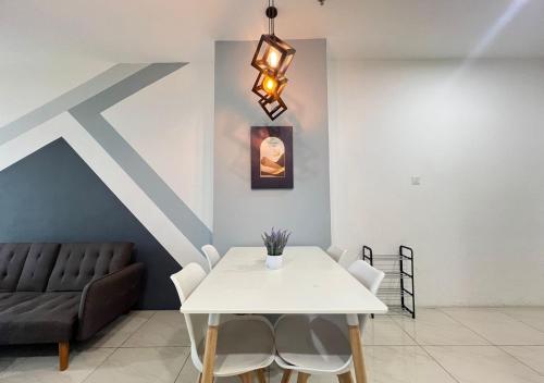a dining room with a white table and a couch at ITCC Manhattan by IGVC in Penampang