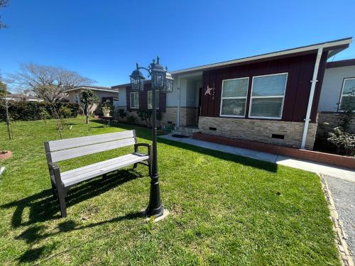 a park bench next to a light pole in front of a house at Cozy Beautiful Private Home in Prime Location in Glendora