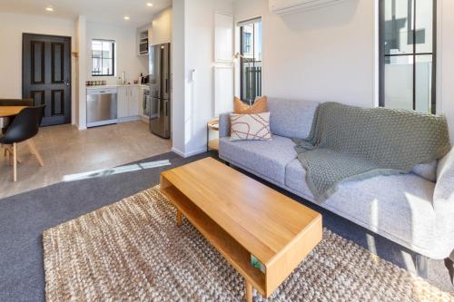 a living room with a couch and a coffee table at Upscale Townhouse with Parking in Prime Location in Christchurch