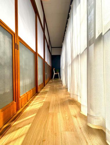 an empty hallway with windows and wooden floors at Japan Kominka in perfect location for Mount FUJI trip in Fujiyoshida