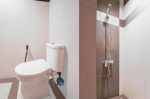a bathroom with a toilet and a shower at Hotel O Brawijaya Near Universitas Brawijaya Formerly Harmonie Residence in Malang