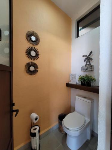 a bathroom with a toilet and two mirrors on the wall at Casa Los Pinos, with a lake view in Avándaro in Valle de Bravo