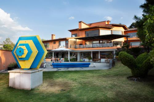 a yellow and blue sign in front of a building at Casa Los Pinos, with a lake view in Avándaro in Valle de Bravo