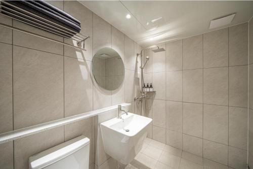a bathroom with a sink and a toilet and a mirror at Brown Dot Hotel South Gumi in Yangji-mal