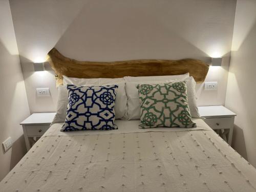 a bedroom with a white bed with blue pillows at Koralline accommodation in Tropea