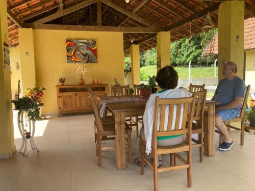 a man and a woman sitting at a table at Sitio Sao Francisco de Assis in Santo Antônio do Pinhal