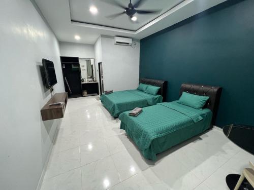 two beds in a room with a blue wall at HMI Roomstay in Pantai Cenang