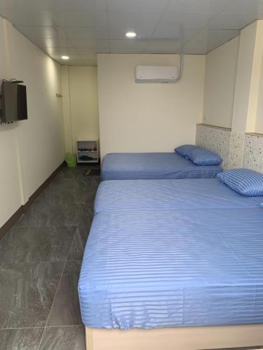 a bedroom with two beds and a flat screen tv at Home run Homestay in Dongyin