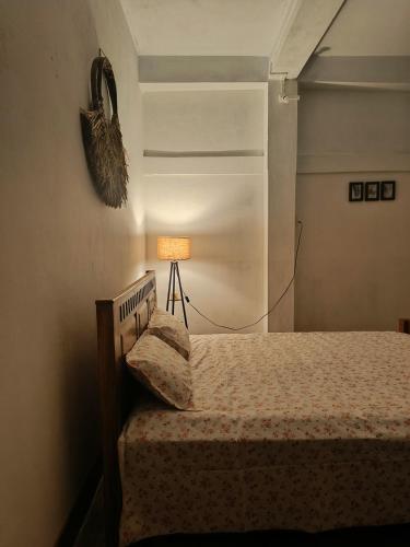 a bedroom with a bed and a lamp in a room at Green Vista Homestay in Silchar