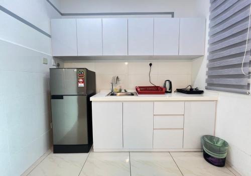 a small kitchen with a refrigerator and a sink at ITCC Manhattan by IGVC in Penampang