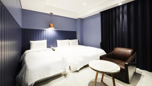 a bedroom with a large bed and a chair at 알마비즈니스호텔 in Jincheon