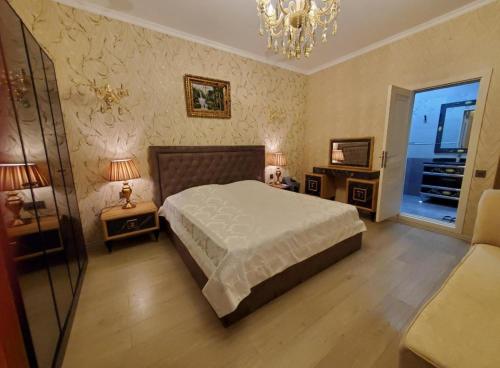 a bedroom with a bed and two lamps and a chandelier at Museum Boutique Luxury GH in Sheki