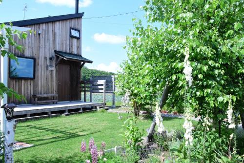 a garden with a wooden house with a tree at mizuki natural villa Garden in Higashikawa