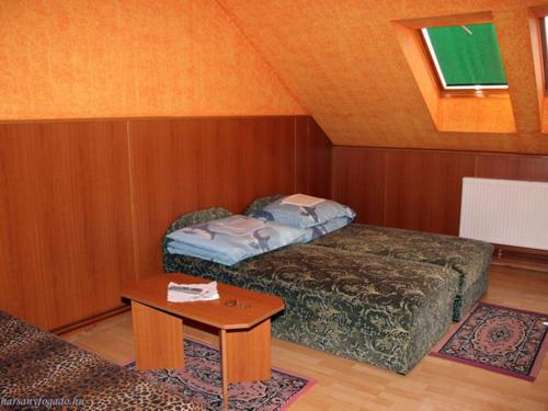 mały pokój z łóżkiem i stołem w obiekcie Harsona Fogadó w mieście Harsány