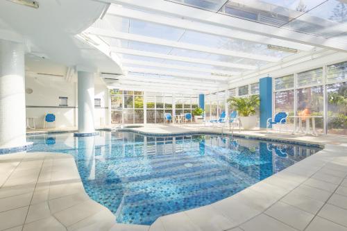 Una gran piscina con agua azul en un edificio. en Burleigh Surf Apartments, en Gold Coast