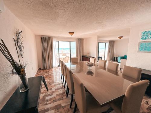 Un comedor con una mesa y sillas blancas. en Deluxe Ocean Villas Marlin, en Cancún
