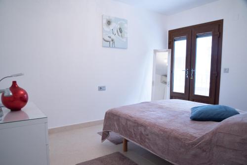 a bedroom with a bed and a vase on a table at St Germain in Moraira
