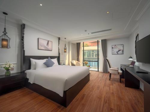 a bedroom with a large white bed and a desk at 22 Land Hotel in Hanoi