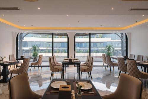a dining room with tables and chairs and windows at 22 Land Hotel in Hanoi