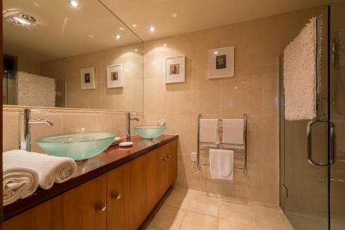 a bathroom with two sinks and a shower at Titore Lodge in Russell