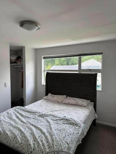 a bedroom with a large bed with a window at Clonbunny homestay in Rolleston
