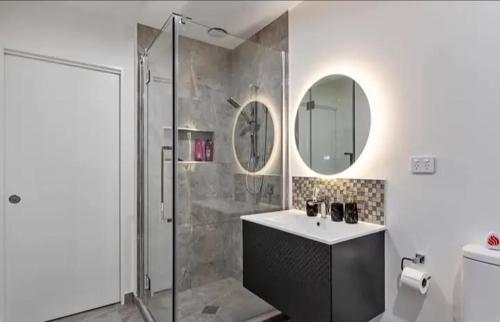 a bathroom with a shower and a sink and a mirror at Clonbunny homestay in Rolleston
