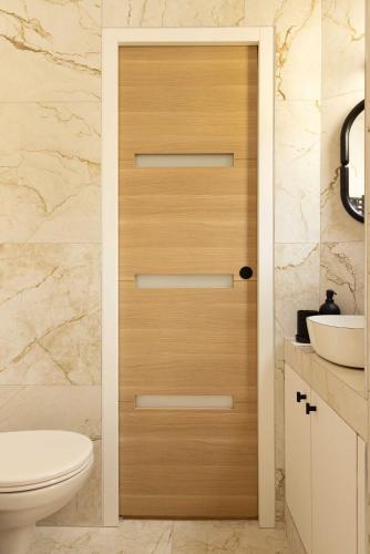 une salle de bain avec toilettes et porte en bois dans l'établissement Charming studio A C - 2P- Montorgueil, à Paris