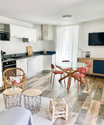 une cuisine et un salon avec une table et des chaises dans l'établissement Le Layris - Maison indépendante avec cour, à Campan