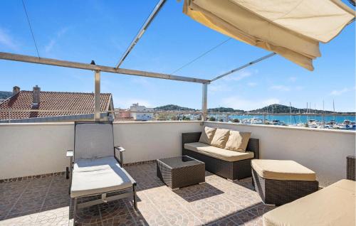 a balcony with a couch and chairs on a roof at Holiday Home Murter 18 With Seaview in Murter