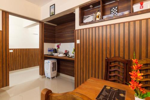 a room with wooden walls and a table and a kitchen at Sancta Maria Lounge -cochin Airport in Nedumbassery