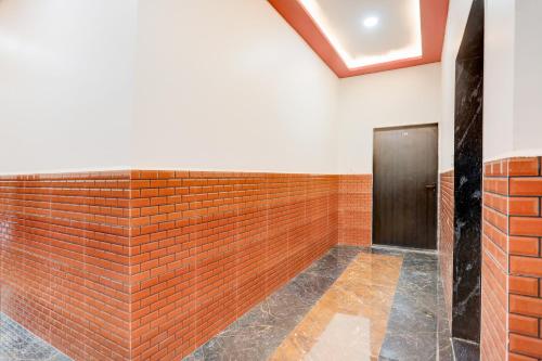 a brick wall in a room with a door at Hotel O Om Sai inn in Prayagraj