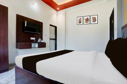 a bedroom with a white bed and a tv at Hotel O Om Sai inn in Prayagraj