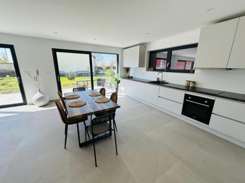 une cuisine et une salle à manger avec une table et des chaises dans l'établissement Maison neuve à 8 min de Colmar, à Oberhergheim
