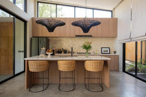 a kitchen with a large island with bar stools at Villa Zara Spacious, Chic and Classy 2 Bedroom Home 5 minutes from Uluwatu Cliff Edge in Uluwatu