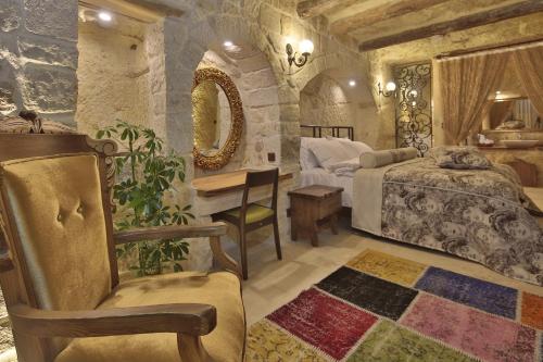 a bedroom with a bed and a desk and a chair at Asuwari Suites Cappadocia in Ürgüp